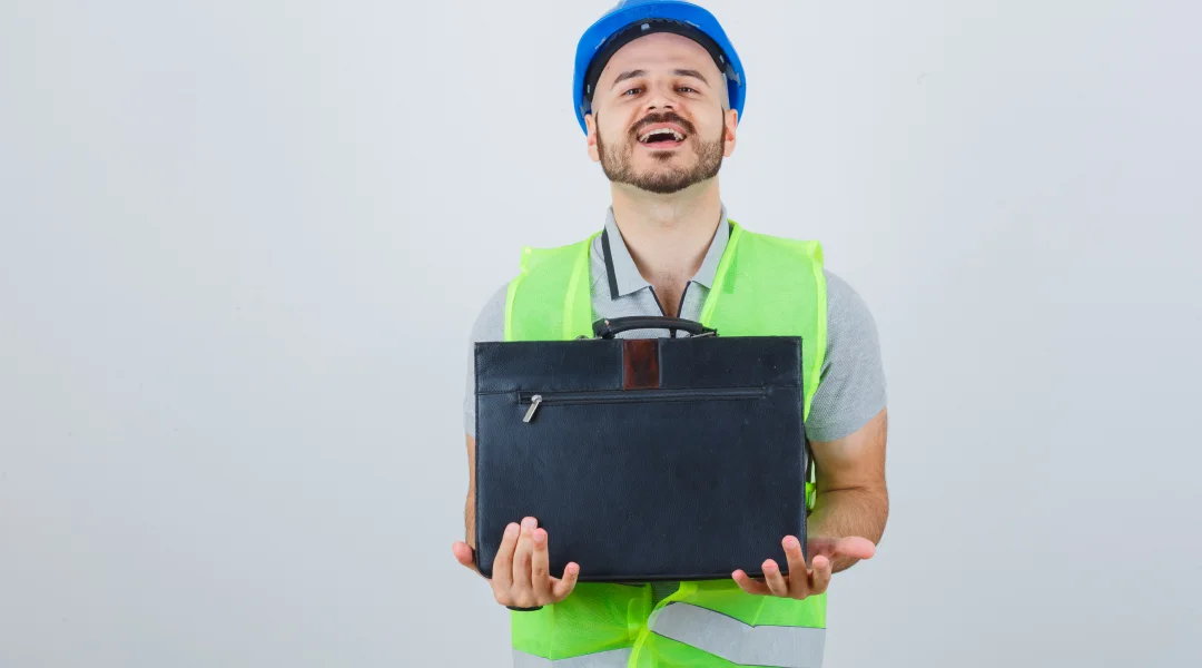 A man in a hard hat holds a briefcase, symbolizing construction and work permit guidance in Canada.
