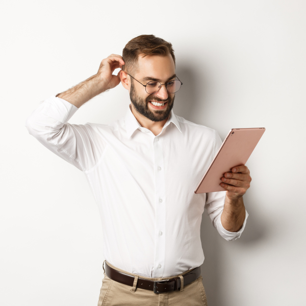 Một người đàn ông đeo kính đang cầm một máy tính bảng.