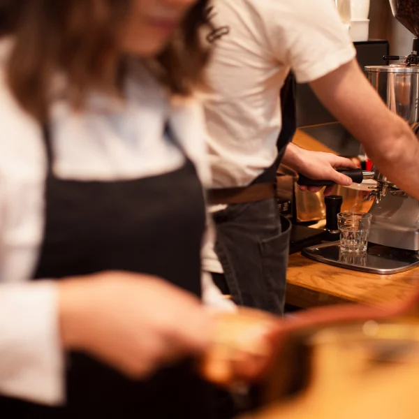 Người phụ nữ mặc tạp dề đen, biểu thị cho công việc trong ngành dịch vụ.