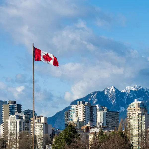 Cờ Canada bay trước đường chân trời thành phố Vancouver, BC, Canada.
