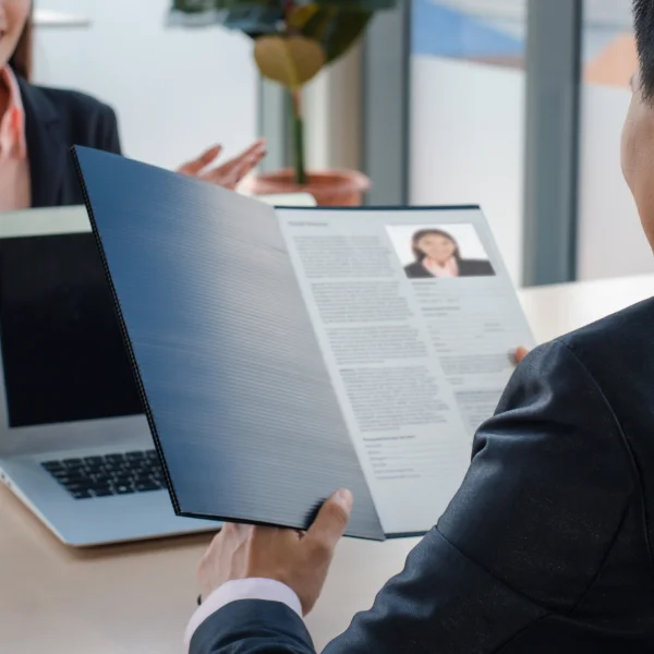 A man and woman sit at a table in Canada, reviewing a resume together.