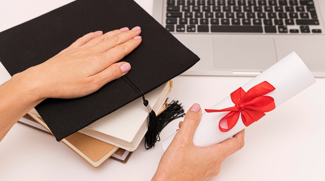 Người cầm bằng tốt nghiệp và laptop, biểu thị thành công trong học tập và công nghệ.